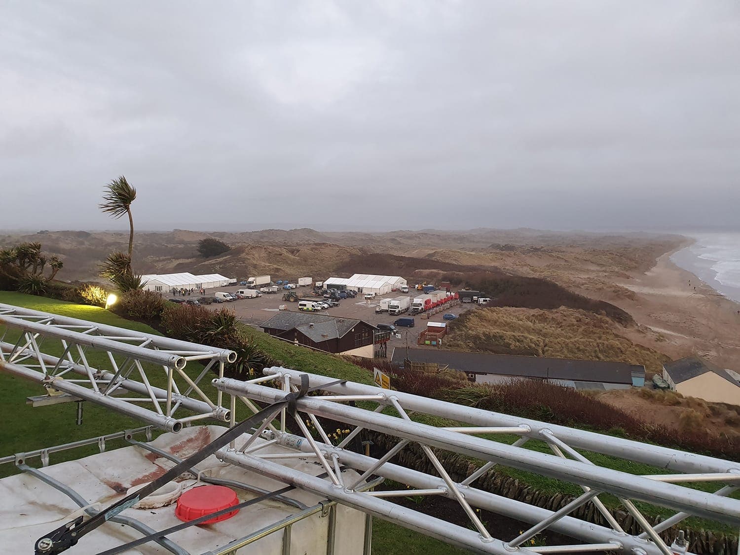Temporary unit base and marquees beside a beach under an overcast sky