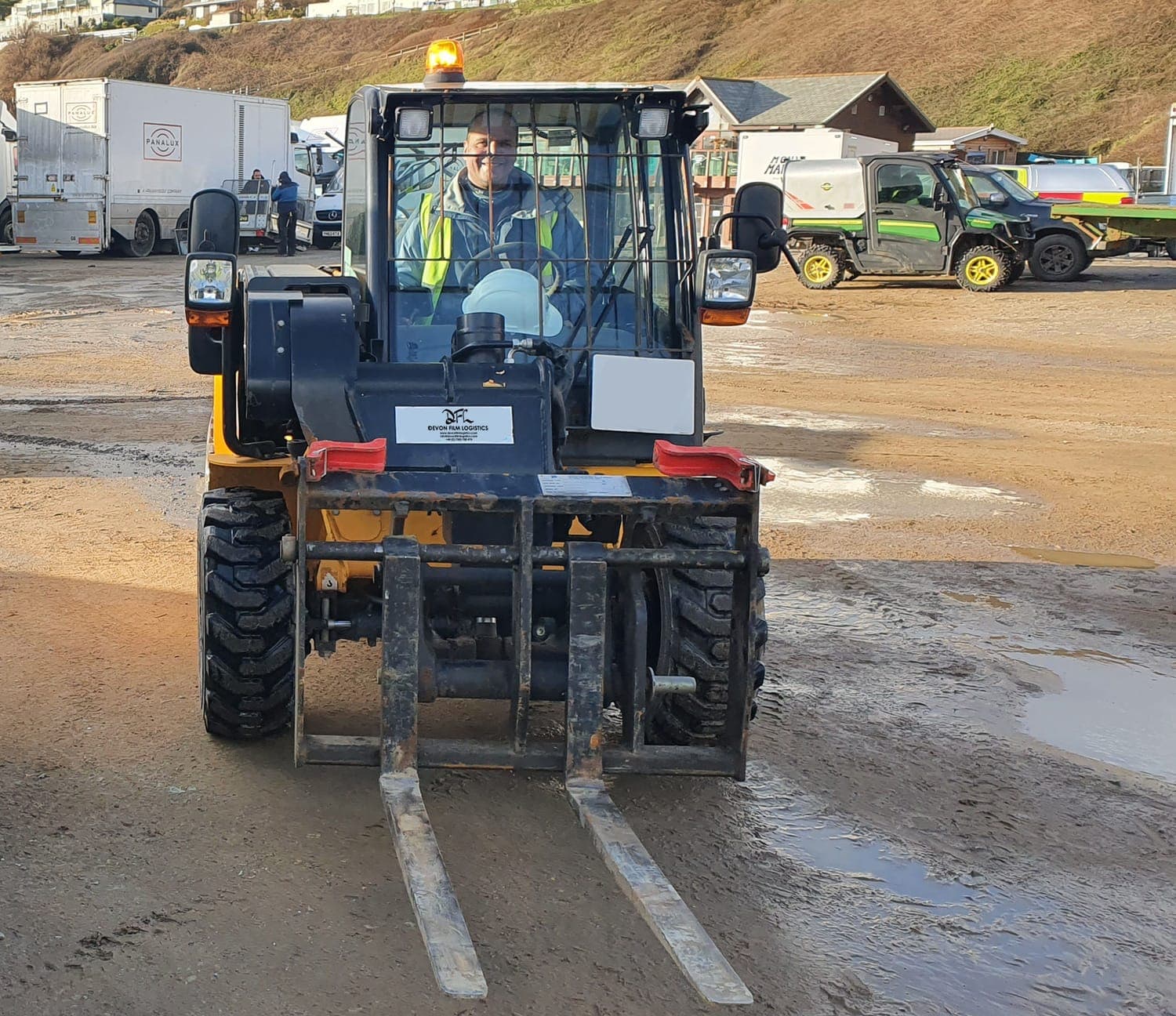 Forklift operator driving a DFL-branded forklift at a coastal unit base