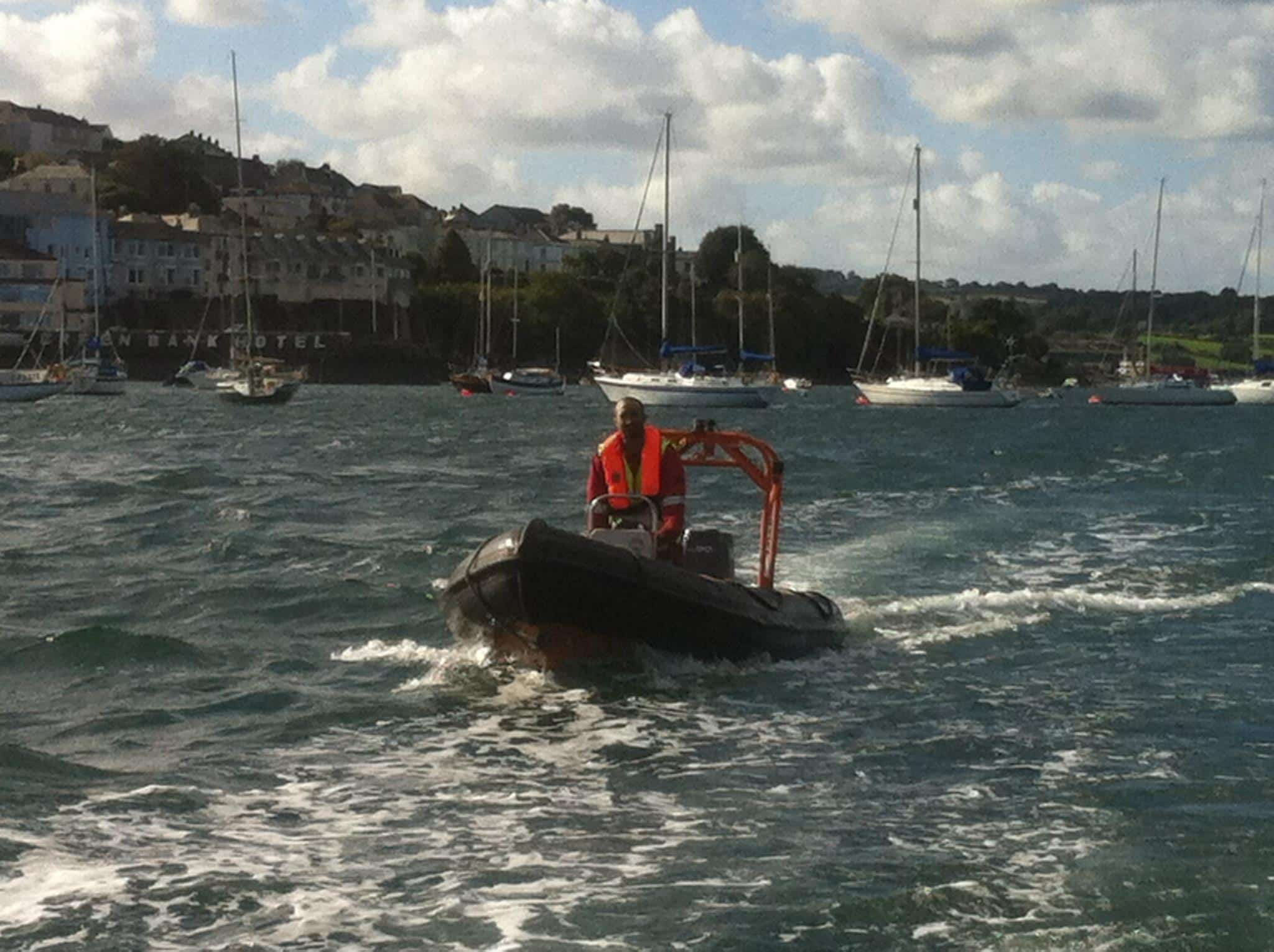 Crew member operating a rigid inflatable support boat in a harbour