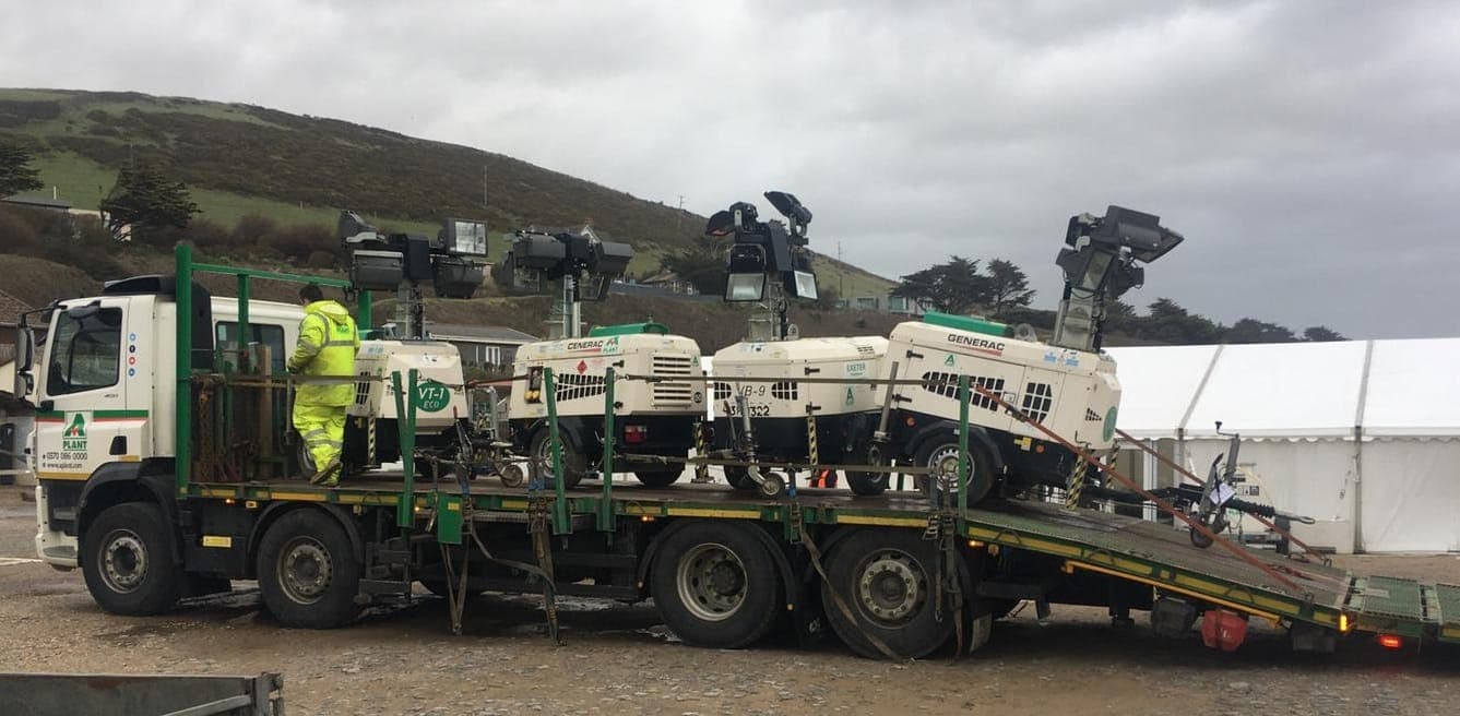 Mobile lighting towers secured on a delivery vehicle