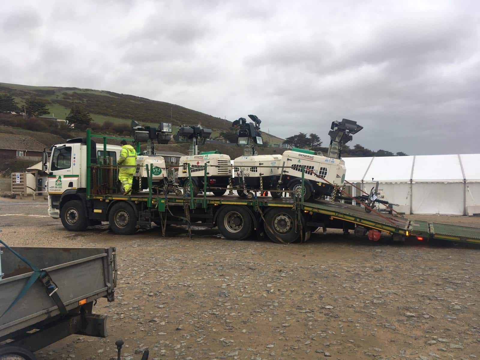 Mobile lighting towers secured to a flatbed delivery lorry