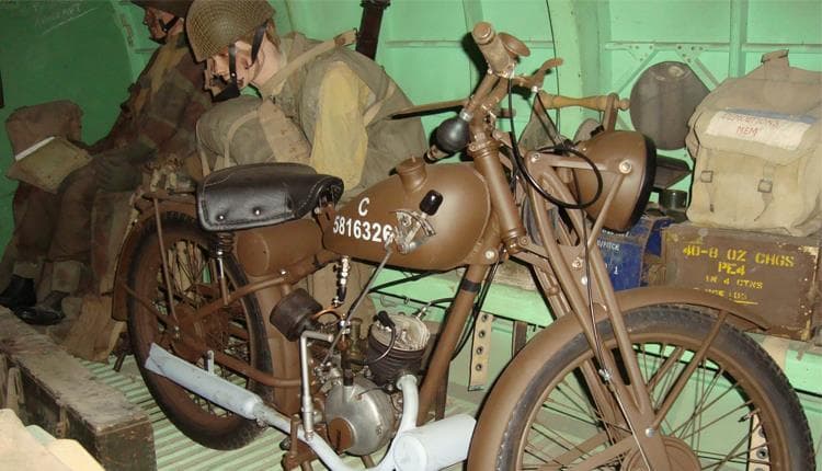 Historic military motorcycle displayed with period equipment